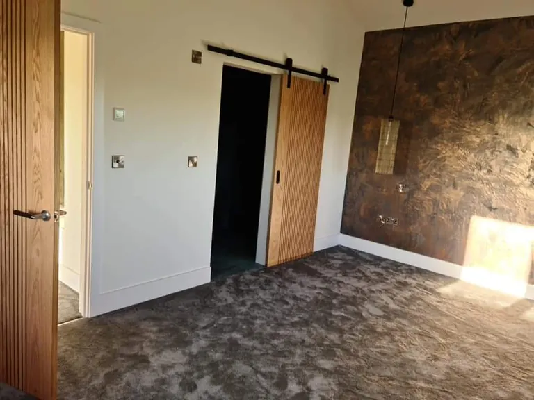Sliding oak barn door and oak door in a newly finished room